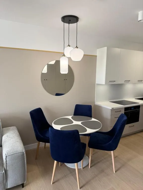 Essbereich mit rundem Tisch und blauen Stühlen